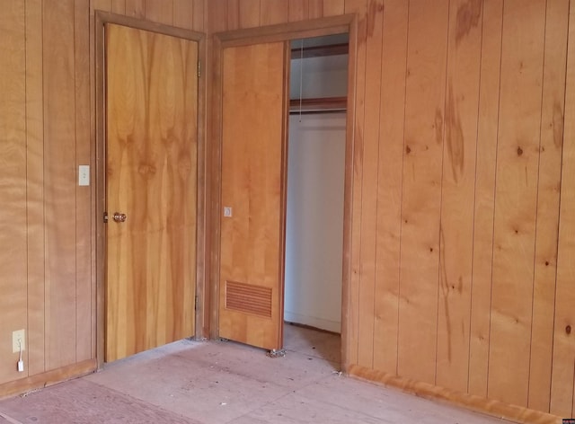 unfurnished bedroom featuring wood walls