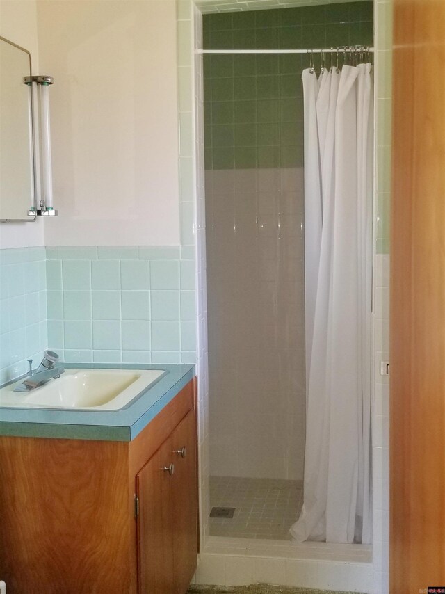 bathroom featuring vanity, backsplash, tile walls, and curtained shower