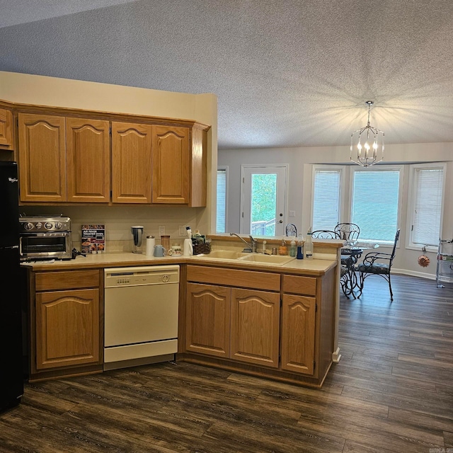 kitchen featuring dark wood-type flooring, sink, hanging light fixtures, and white dishwasher