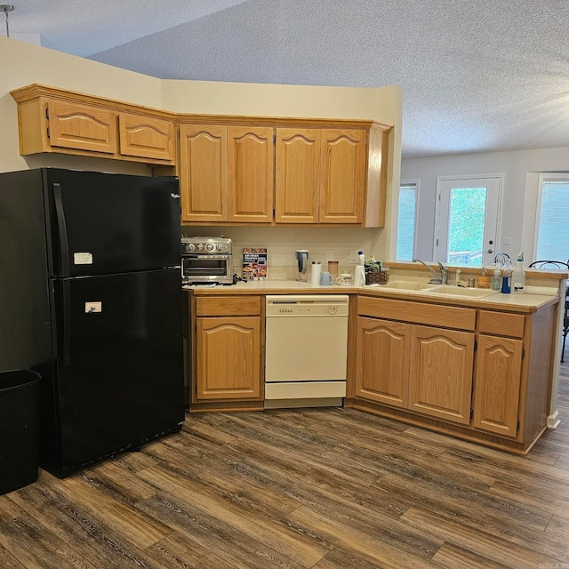 kitchen with black fridge, sink, dishwasher, dark hardwood / wood-style floors, and a textured ceiling