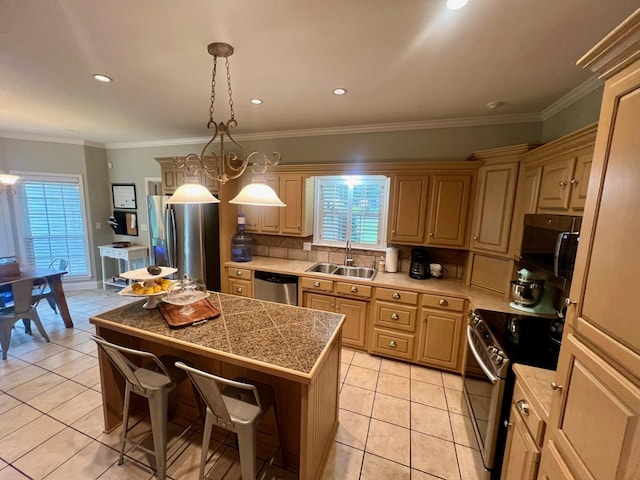 kitchen featuring appliances with stainless steel finishes, a kitchen island, sink, ornamental molding, and light tile patterned floors