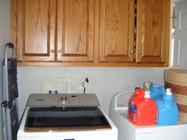 washroom featuring separate washer and dryer and cabinets