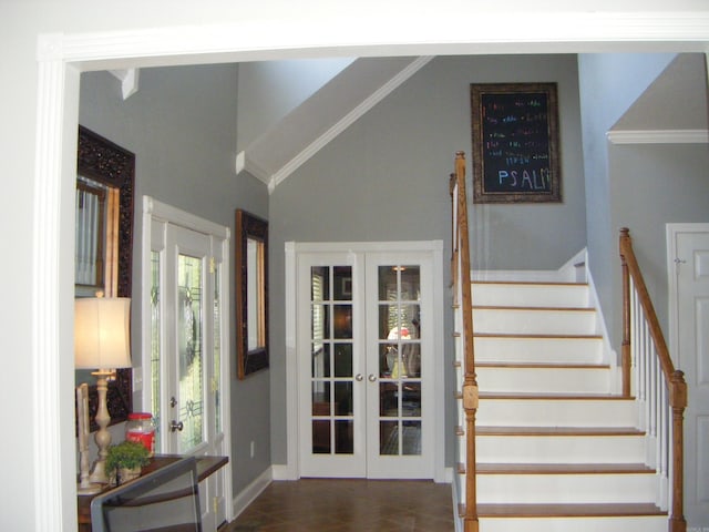 stairs with lofted ceiling, crown molding, and french doors