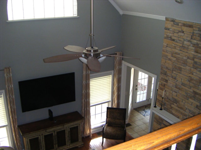 living room featuring ceiling fan, crown molding, and tile patterned floors