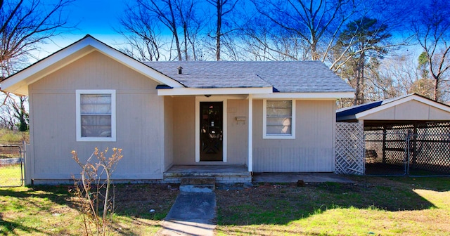 bungalow-style home featuring a front lawn and a carport