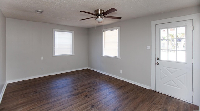 foyer with dark wood-type flooring, a textured ceiling, and ceiling fan