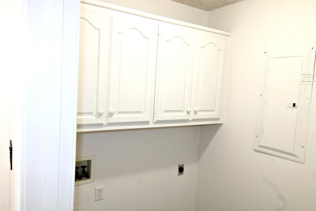 clothes washing area featuring cabinets, a textured ceiling, electric panel, washer hookup, and hookup for an electric dryer