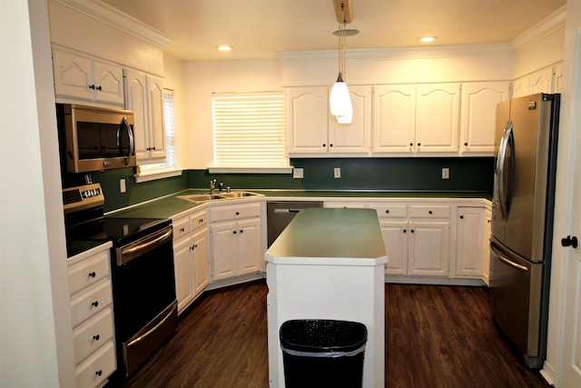 kitchen with pendant lighting, stainless steel appliances, a center island, and white cabinets