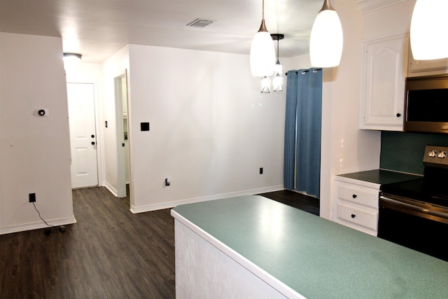 kitchen featuring pendant lighting, white cabinetry, dark wood-type flooring, and appliances with stainless steel finishes