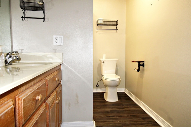 bathroom with wood-type flooring, vanity, and toilet