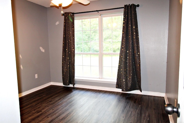 unfurnished room with dark hardwood / wood-style flooring and ceiling fan