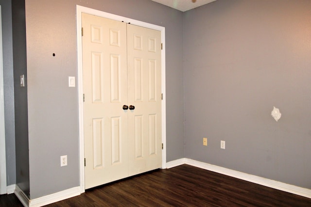 unfurnished bedroom featuring dark hardwood / wood-style floors and a closet