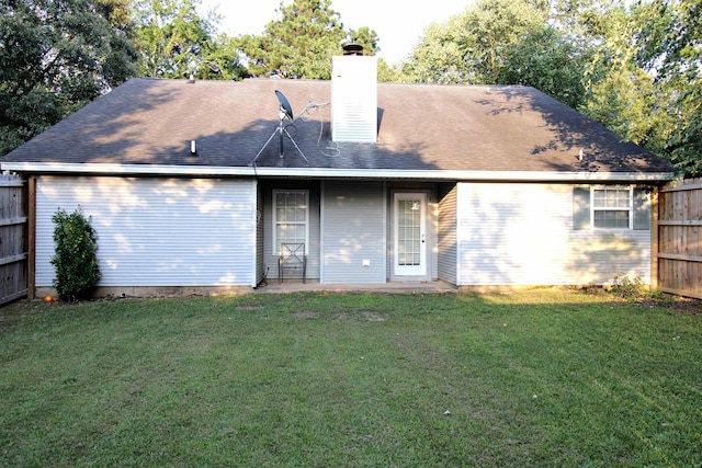 rear view of property featuring a yard