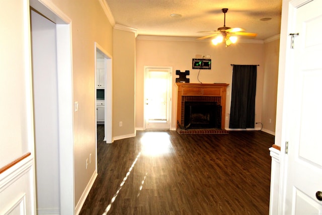 unfurnished living room featuring dark hardwood / wood-style floors, a fireplace, ceiling fan, crown molding, and a textured ceiling