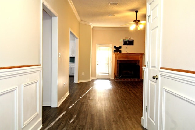 hallway with crown molding, dark hardwood / wood-style floors, and a textured ceiling