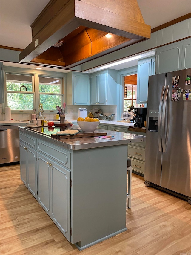 400 Neill Rd, Helena, AR 72342 - kitchen with appliances with stainless steel finishes, light hardwood / wood-style flooring, tasteful backsplash, a wealth of natural light, and a center island