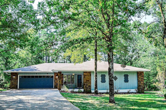 ranch-style house featuring a garage and a front lawn