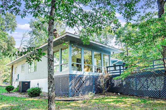 view of property exterior featuring central AC unit and a sunroom