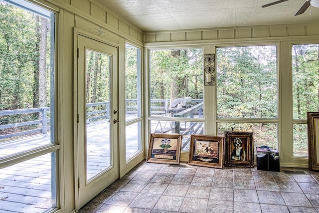 unfurnished sunroom with ceiling fan and plenty of natural light