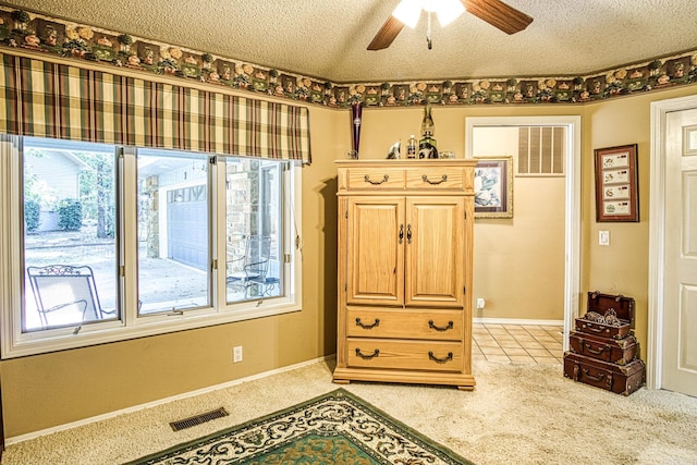 carpeted bedroom with a textured ceiling and ceiling fan