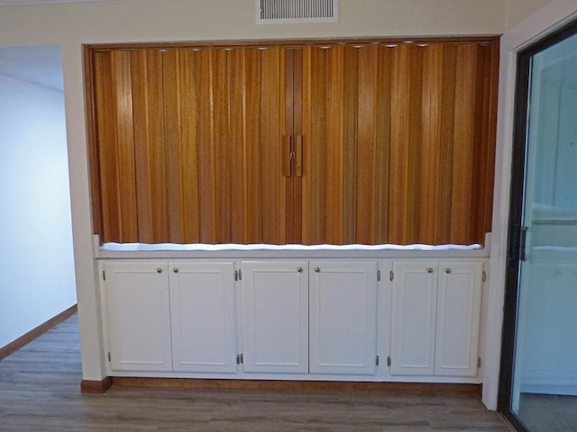 interior space with wood finished floors, visible vents, and baseboards