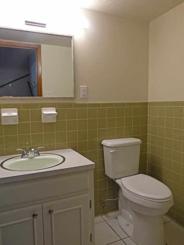 bathroom with tile patterned flooring, toilet, visible vents, vanity, and tile walls