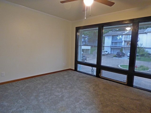 empty room featuring carpet flooring, crown molding, and baseboards