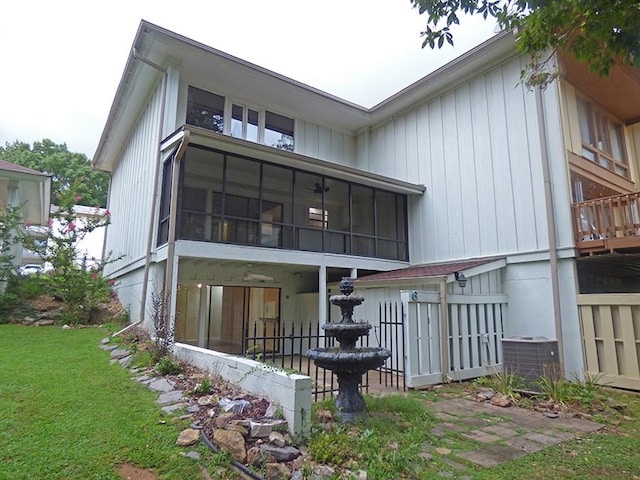 rear view of property featuring central AC and a sunroom