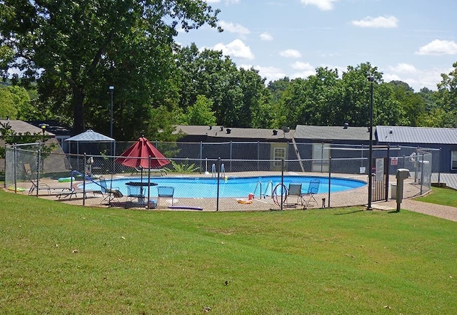 pool featuring fence and a yard