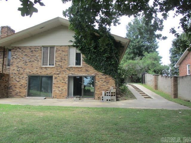 back of property with a lawn and a patio area