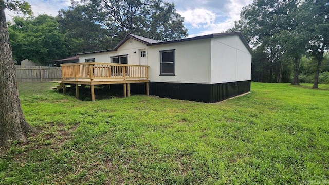 rear view of house with a yard and a deck