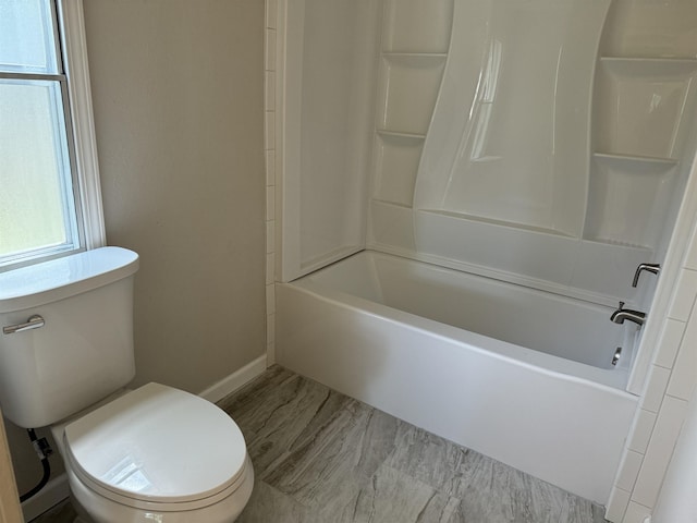 bathroom featuring shower / tub combination and toilet