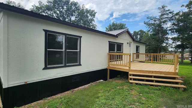 back of property featuring a yard and a deck