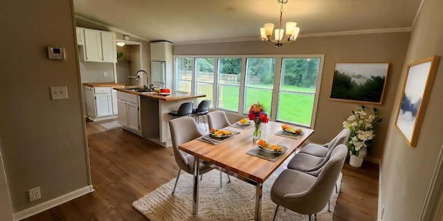 dining space with ornamental molding, dark hardwood / wood-style floors, a chandelier, and sink