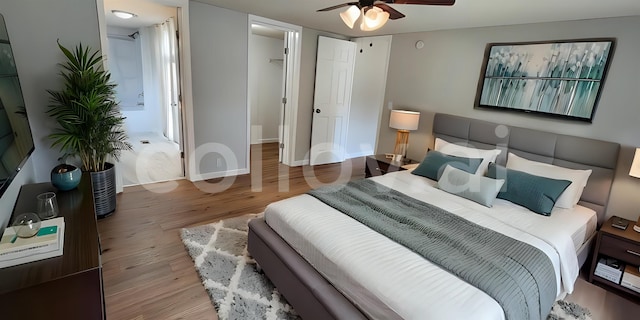 bedroom with a spacious closet, wood-type flooring, a closet, and ceiling fan