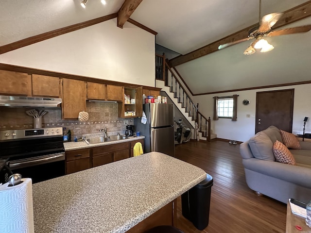 kitchen with appliances with stainless steel finishes, beamed ceiling, light countertops, under cabinet range hood, and a sink