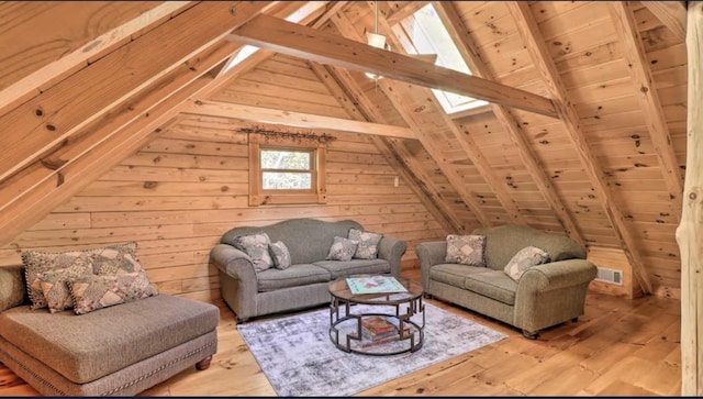 bedroom with carpet, beam ceiling, and wooden walls