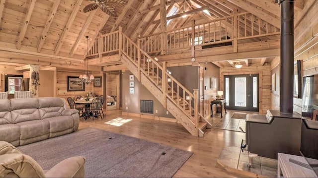 dining room with wood walls, beam ceiling, high vaulted ceiling, and wood ceiling