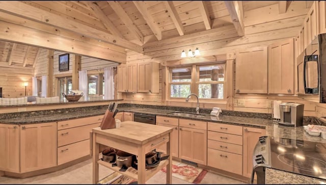 kitchen with light brown cabinetry, a breakfast bar, high vaulted ceiling, dark stone countertops, and gas stove