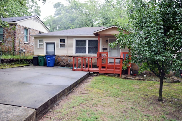 view of front of property with a wooden deck and a front yard