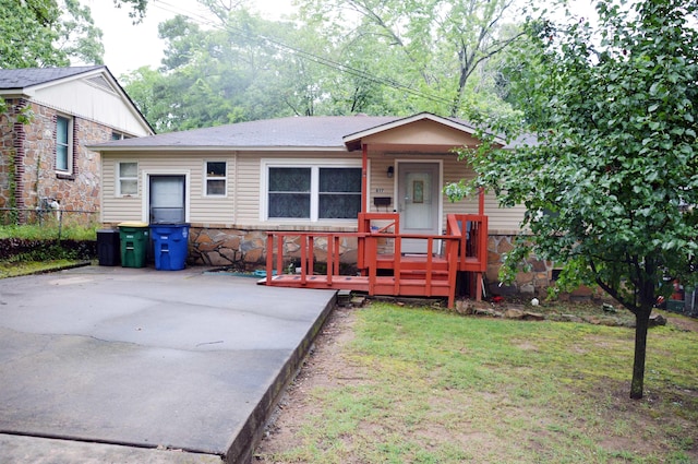 view of front of house with a wooden deck and a front yard