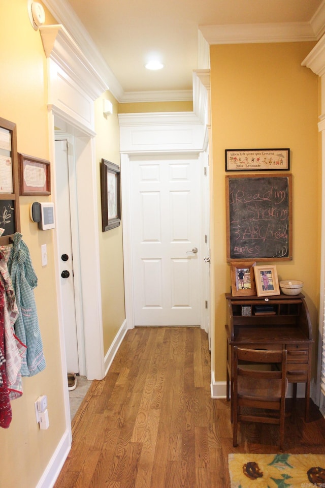 hallway featuring wood-type flooring and ornamental molding