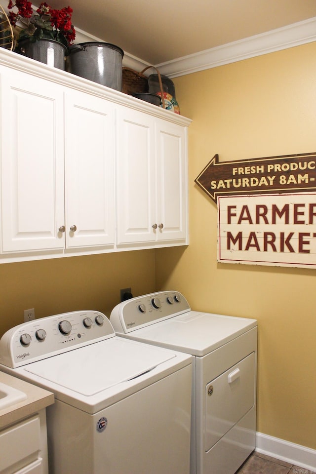 laundry room featuring separate washer and dryer, cabinets, and crown molding