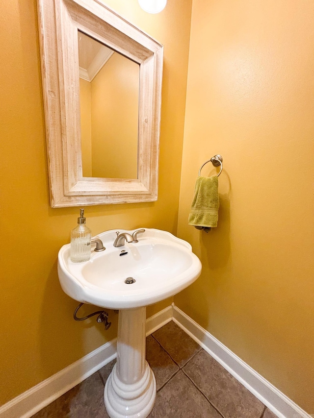 bathroom with crown molding and tile patterned flooring