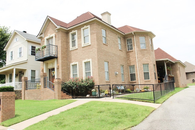 view of front of property with a balcony and a front lawn