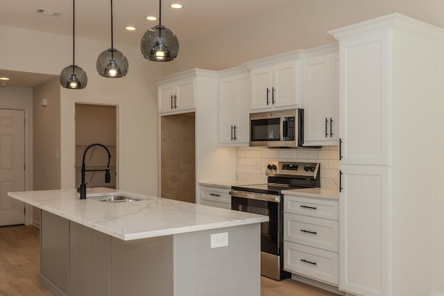 kitchen featuring visible vents, white cabinets, decorative backsplash, stainless steel appliances, and a sink