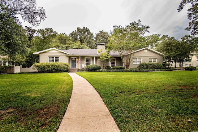 ranch-style home with a front yard and a chimney