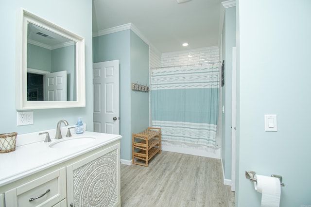 full bathroom with ornamental molding, curtained shower, vanity, and wood finished floors