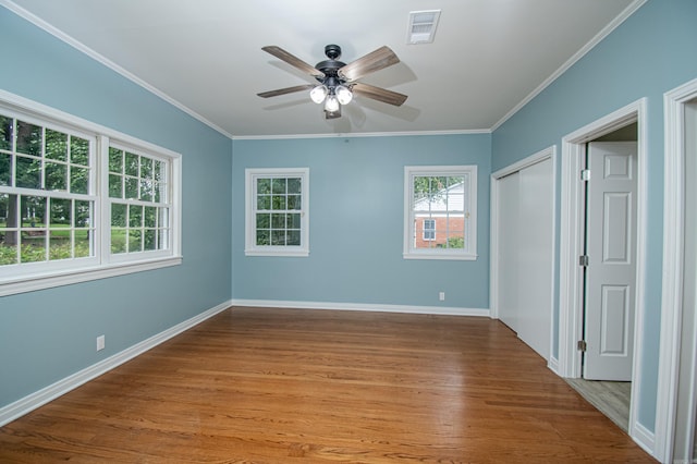 empty room with ceiling fan, crown molding, and hardwood / wood-style flooring