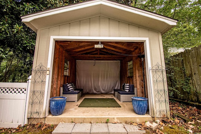 view of outbuilding with a garage, fence, and an outbuilding